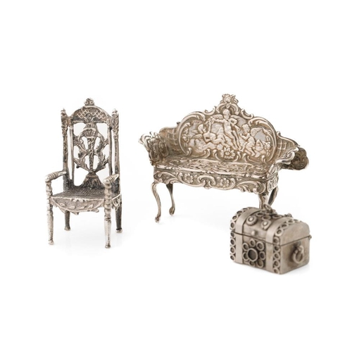 152 - Silver miniature dolls house sofa with cherub decoration, Birmingham 1962, a silver chair and a trun... 