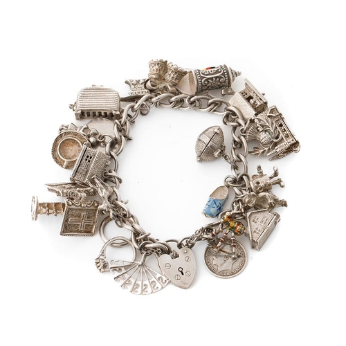 216 - Silver charm bracelet with various charms to include a house, an anvil, a toaster, a book and others... 