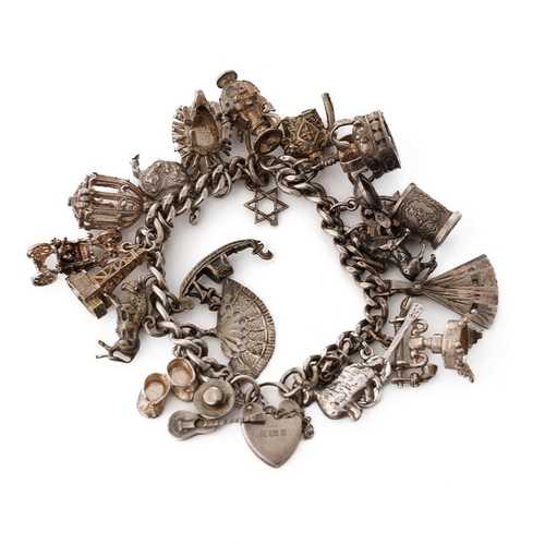 218 - Silver charm bracelet with various charms to include a tankard, a fan, a crab, a bull and others, 69... 