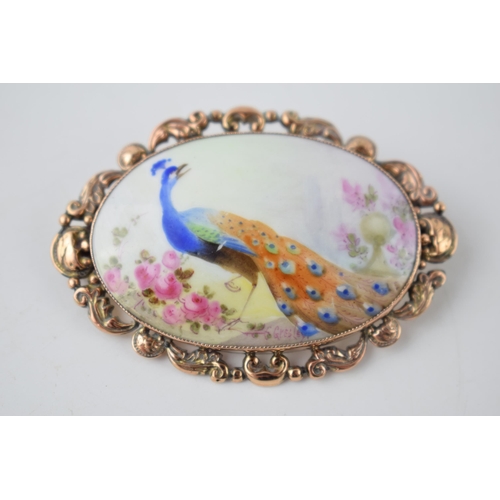 206 - C Gresley hand painted miniature oval brooch with a peacock amongst foliage, in 9ct gold mount, 60mm... 