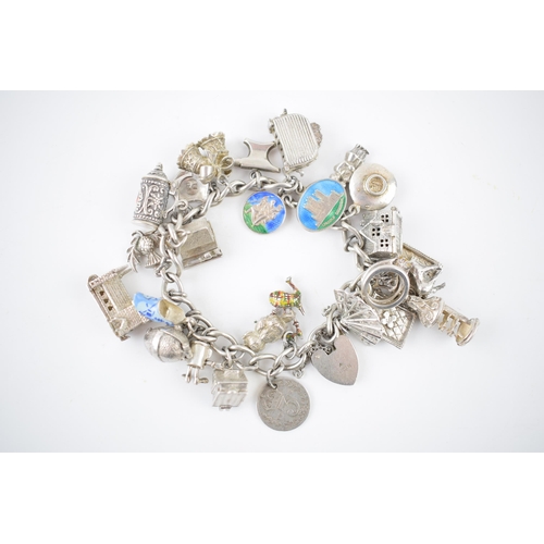 216 - Silver charm bracelet with various charms to include a house, an anvil, a toaster, a book and others... 