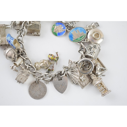 216 - Silver charm bracelet with various charms to include a house, an anvil, a toaster, a book and others... 