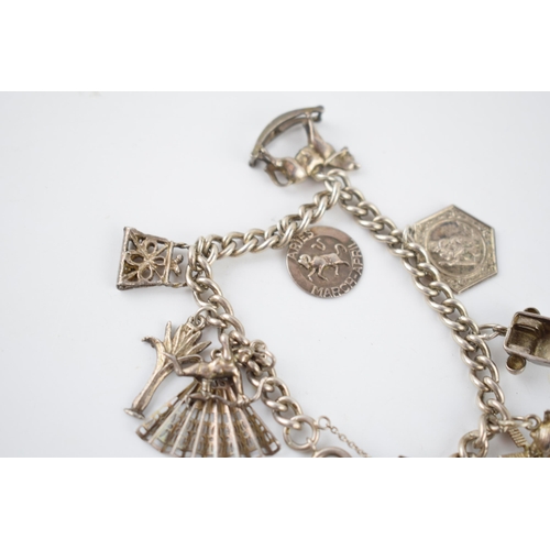 217 - Silver charm bracelet with various charms to include Cupid, a fan, a rocking horse and others, 37.5 ... 