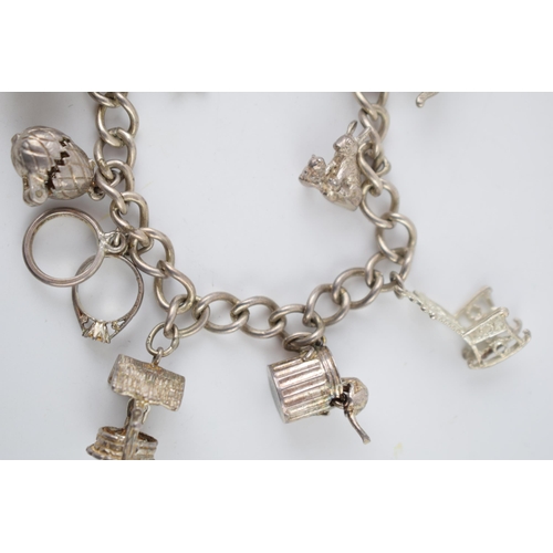 219 - Silver charm bracelet with various charms to include a hedgehog, a pair of rabbits, a well and other... 