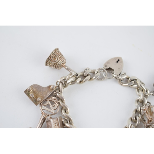 224 - Silver charm bracelet with various charms to include a football, a bell, a tankard, a fire engine an... 