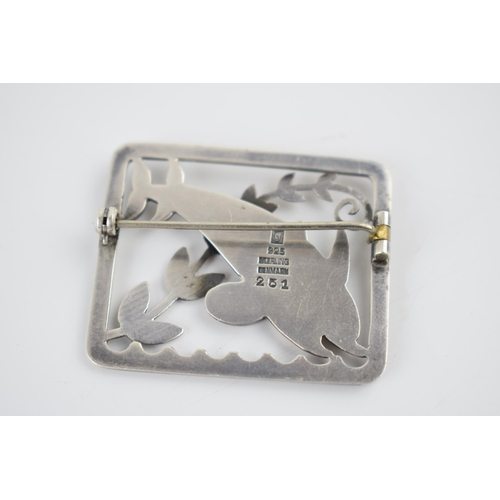 235 - A Georg Jensen silver brooch, designed by Arno Malinowski. 'Leaping Dolphins' in a rectangular frame... 