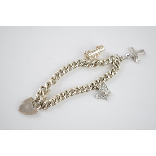 237 - Silver charm bracelet with charms to include a car, a cross and others, 34.7 grams.