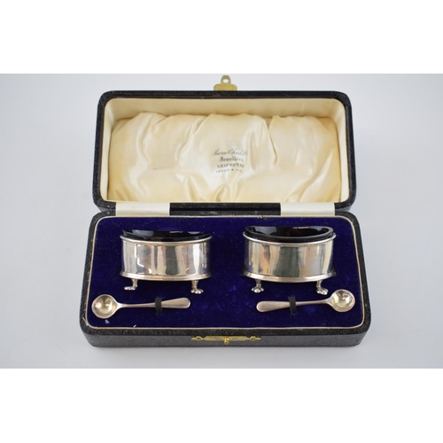 136 - Cased pair of silver salts, with blue glass liners with silver spoons, London 1923, 49.5 grams.