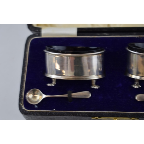 136 - Cased pair of silver salts, with blue glass liners with silver spoons, London 1923, 49.5 grams.