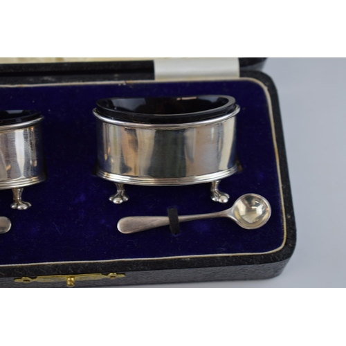 136 - Cased pair of silver salts, with blue glass liners with silver spoons, London 1923, 49.5 grams.