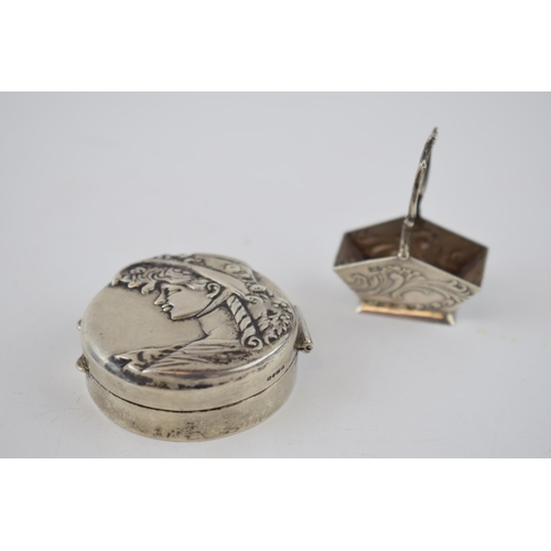 154 - Silver circular pill box depicting a girl in bonnet with a silver miniature log bucket with raised h... 