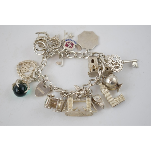 330 - Silver charm bracelet to include Big Ben, London Bridge, keys and others, 68.7 grams.