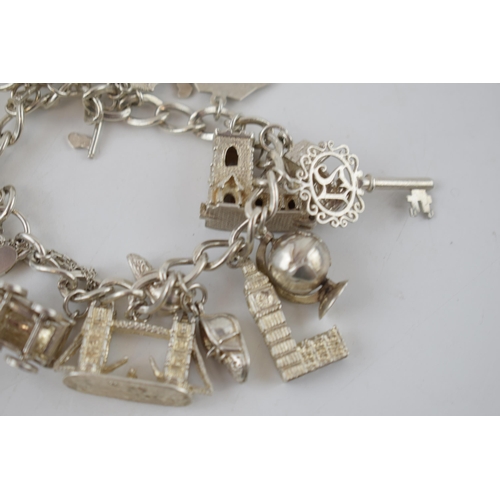 330 - Silver charm bracelet to include Big Ben, London Bridge, keys and others, 68.7 grams.