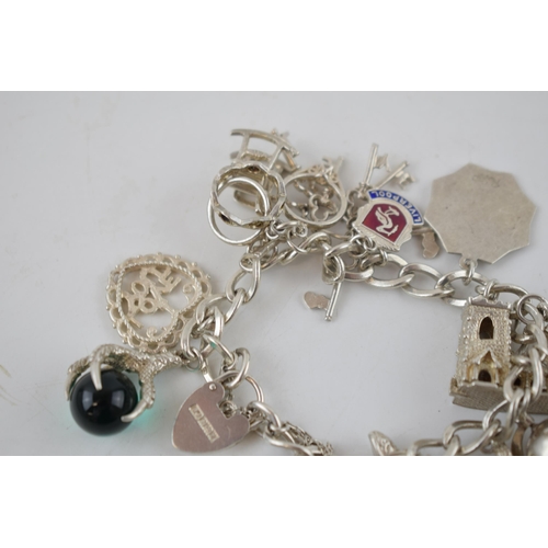 330 - Silver charm bracelet to include Big Ben, London Bridge, keys and others, 68.7 grams.