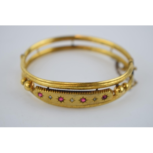 358 - Victorian pinchbeck bangle set with 4 rubies and 3 diamond chips, 65mm diameter.