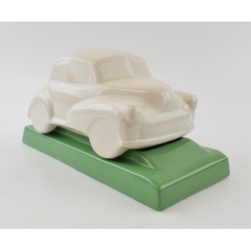 134 - Ceramic desk tidy in the form of a Morris Minor car. Green base with a cream car. Length 27cm, heigh... 