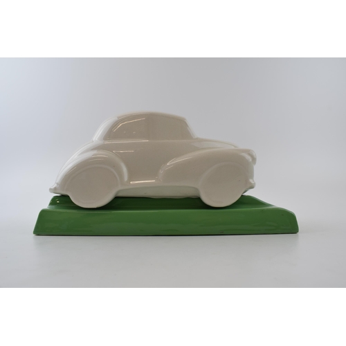 134 - Ceramic desk tidy in the form of a Morris Minor car. Green base with a cream car. Length 27cm, heigh... 