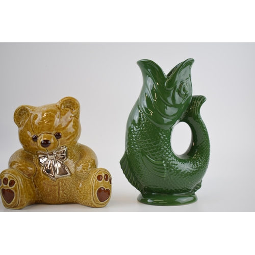 141 - A trio of Wade Ceramics to include 2 Gluggle jugs in green and blue, 22cm tall, with a teddy bear mo... 