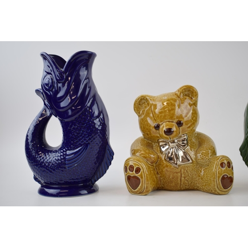 141 - A trio of Wade Ceramics to include 2 Gluggle jugs in green and blue, 22cm tall, with a teddy bear mo... 