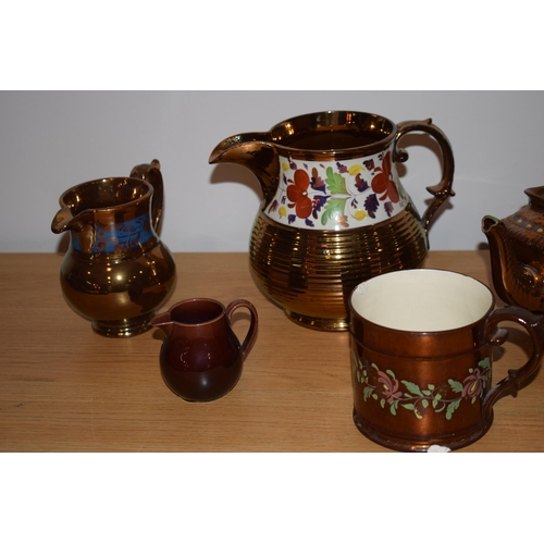 132H - A collection of early 19th century copper lustre items to include a large floral jug, a teapot, a sm... 