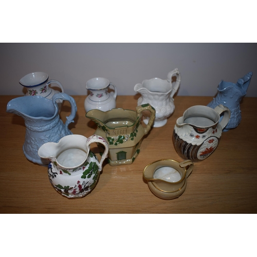 132L - An interesting collection of early 19th century moulded jugs to include a drab ware jug, a moulded h... 