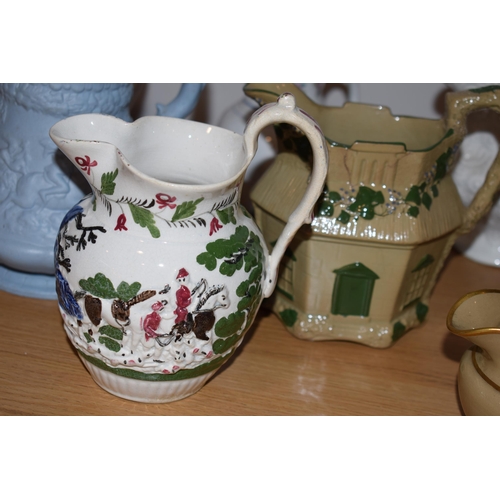 132L - An interesting collection of early 19th century moulded jugs to include a drab ware jug, a moulded h... 