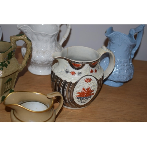 132L - An interesting collection of early 19th century moulded jugs to include a drab ware jug, a moulded h... 