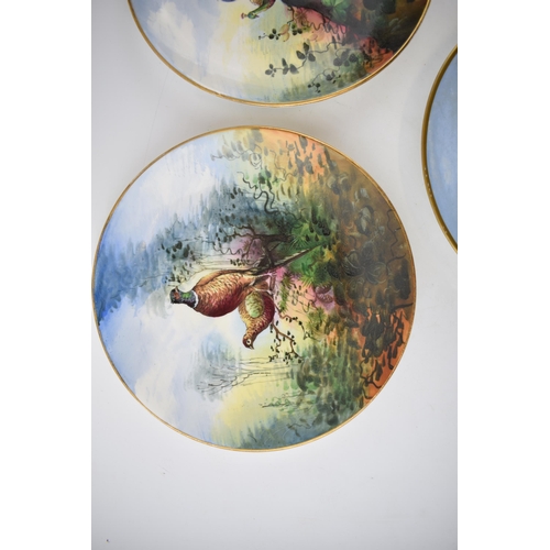 119 - A pair of early 20th century hand painted plates depicting Pheasants and Peacocks together with anot... 