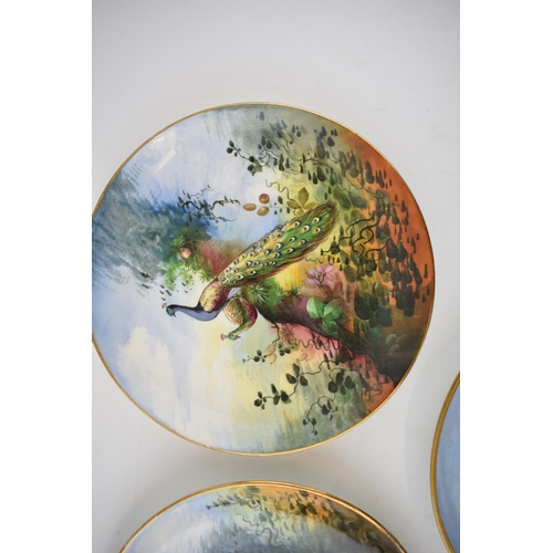 119 - A pair of early 20th century hand painted plates depicting Pheasants and Peacocks together with anot... 