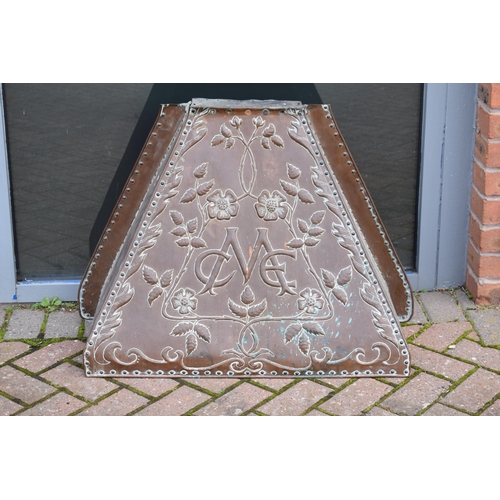 288 - In the manner of John Pearson: an early 20th century embossed copper fire surround / chimney with fl... 