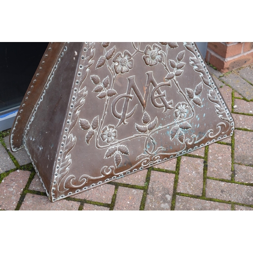 288 - In the manner of John Pearson: an early 20th century embossed copper fire surround / chimney with fl... 