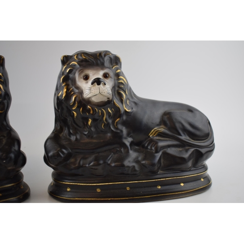 123 - A pair of Staffordshire style ceramic lions. 27 x 23cm