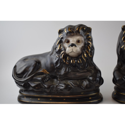 123 - A pair of Staffordshire style ceramic lions. 27 x 23cm