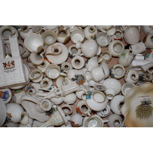 127 - A collection of crested china items to include animals, jugs, vases and varying forms and decoration... 