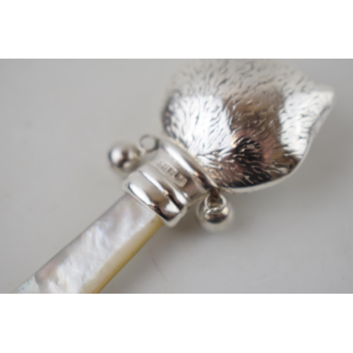 233 - Sterling silver baby rattle with mother of pearl handle in the form of a cat's head, 7.5cm long.