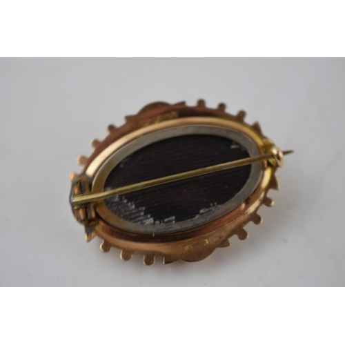 191 - 9ct gold mourning brooch with raised oval centre, 5.1 grams, hallmarks to rear.