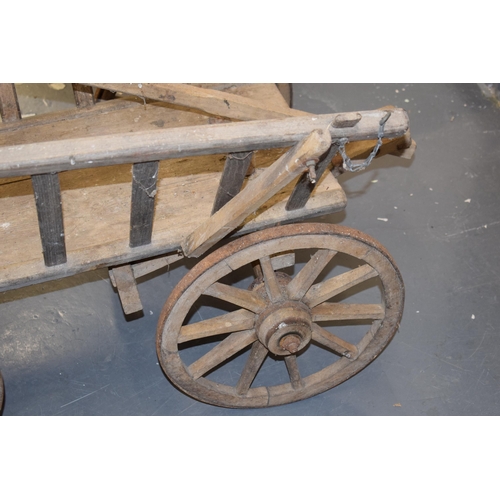 284 - An antique dog cart. Sitting on four hand-made wheels. 100cm x 60cm x 58cm.