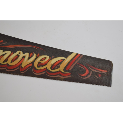 294 - Vintage wooden and metal hand saw with painted 'Tattoos Removed' advertising decor, 66cm wide.