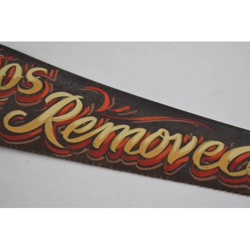 294 - Vintage wooden and metal hand saw with painted 'Tattoos Removed' advertising decor, 66cm wide.