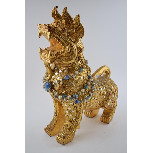 309 - An Oriental style lion with beaded necklace and inlaid mirrors. Height 46cm.