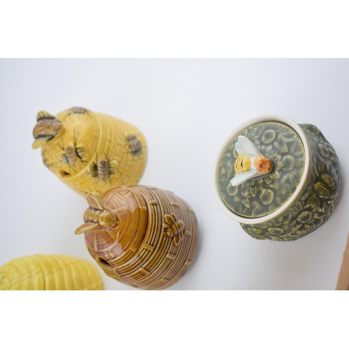 162 - A collection of pottery honey pots in varying forms and colours to include Mintons (wings re-stuck),... 