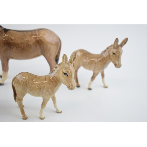 74 - A collection of Beswick Donkeys to include a large donkey with 4 foals (5).