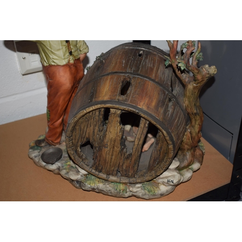 184 - Capodimonte 'La Burla' figural group of a man standing by a barrel with boys hiding inside, 39cm tal... 