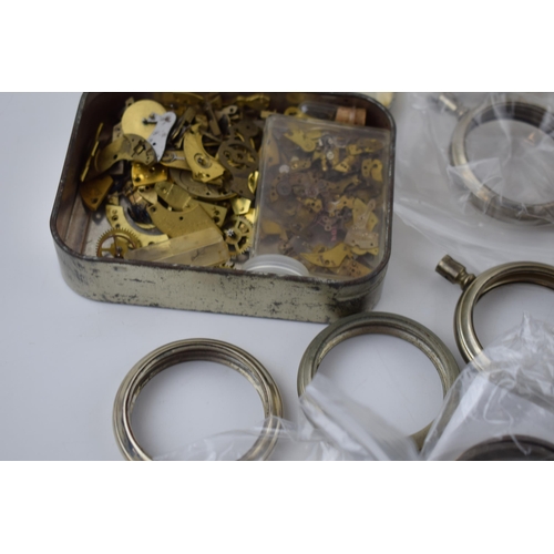 412 - A large quantity of pocket watch parts including movements, cases, crowns, and stems. Of note severa... 