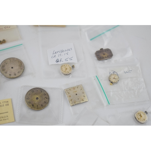 421 - A collection of Longines watch movements and parts. To include rotors, stems, with some NOS parts no... 