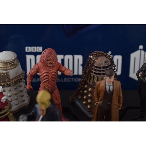 655 - A collection of Doctor Who figures by DW (TM BBC) together with display stand and accompanying magaz... 