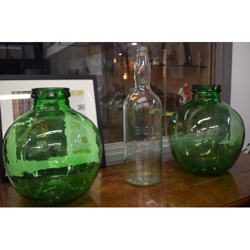 697 - A pair of large Viresa green glass carboys, 35cm tall, together with a Bells Scotch Whisky bottle (3... 