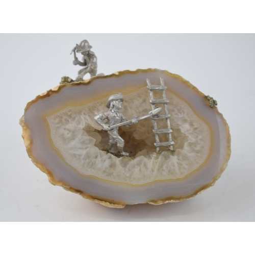 703 - Unusual natural geode with rough cut, in the style of agate, with added mining figures, 12cm wide.