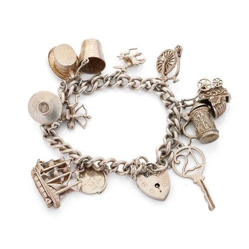 469 - Silver charm bracelet with charms to include a tankard, a key, a bucket and others, 52.6 grams.