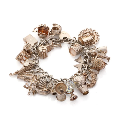 470 - Silver charm bracelet with charms to include a teapot, a crown, a knight and others, 96.9 grams.